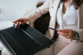 Frau mit Kreditkarte kauft am Laptop online ein