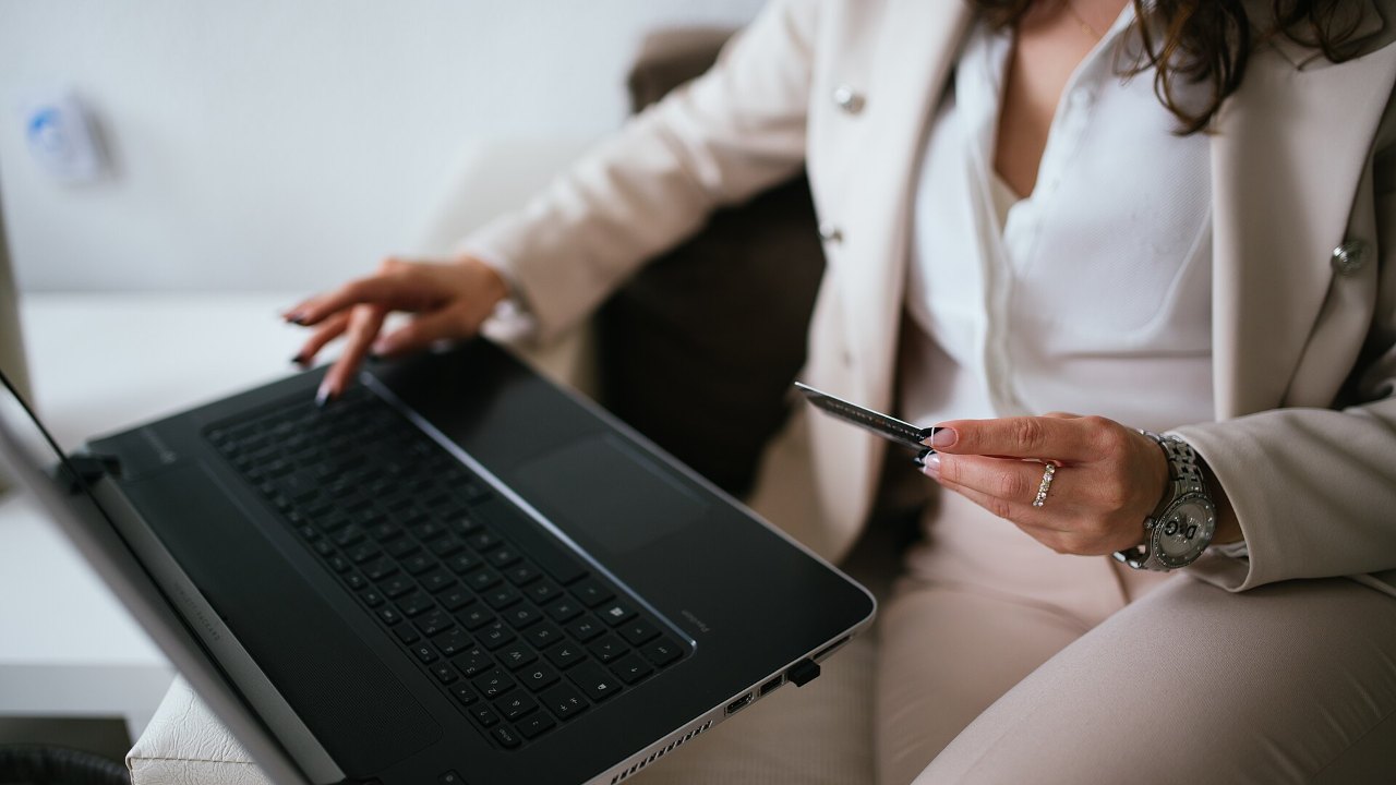Frau mit Kreditkarte kauft am Laptop online ein